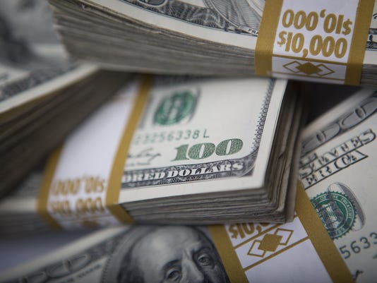 A close up image of stacks of dollar bills